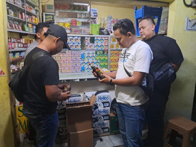
Foto Ist: Petugas Unit Reskrim Polsek Cikupa saat melakukan pemeriksaan dan mengamankan botol minuman beralkohol dalam Operasi Pekat di salah satu toko jamu wilayah Kecamatan Cikupa, Kabupaten Tangerang, Selasa (17/2/2026) malam.