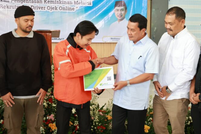 
Foto Ist: Bupati Tangerang, Moch. Maesyal Rasyid, secara simbolis menyerahkan dokumen kepesertaan BPJS Ketenagakerjaan kepada salah satu peserta rekrutmen driver Shopee dalam acara “Langkah Berdaya dan Terlindungi: Gerakan Pengentasan Kemiskinan Melalui Rekrutmen Driver Shopee” di Gedung Serbaguna Kecamatan Kosambi, Jumat (27/02/2026).