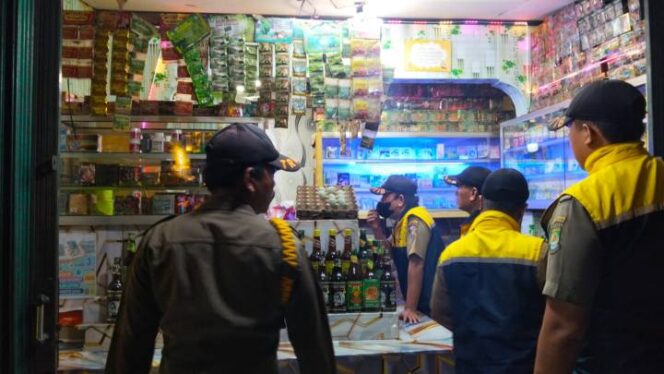 
Foto Ist: Petugas Trantib Kecamatan Cibodas saat melakukan razia dan mengamankan ratusan botol minuman keras di salah satu toko kelontong.